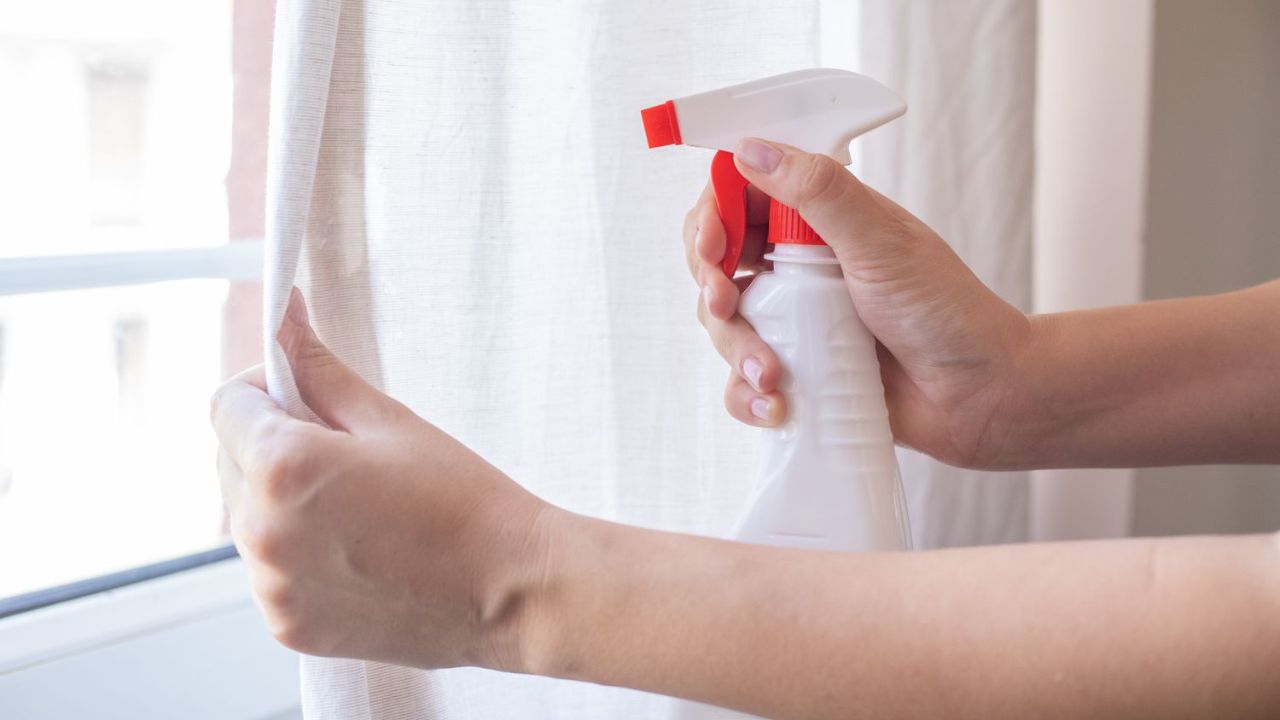 pessoa limpando cortina